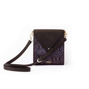 Amana Maggie Bag front view. Black smooth leather bag with front panel black & grey embossed python print. Front flip opening with pin closure, gold zip closure at back, cellphone pocket and zip pocket in front interior, and cross body adjustable strap.