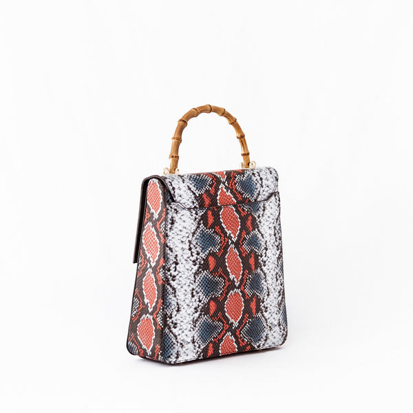 Amana Alexandra Handbag front view. Alexandra bag smooth calf leather embossed with the striking black and orange python design with a bamboo handle and gold hardware details for an elegant finish. Open pocket at the back to slip your items is quickly for safe keeping.