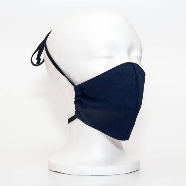Navy Alpha Mask Side View: Solid navy colour fabric face mask contoured to fit comfortably on your face. This is a 3 layer fabric mask with a middle pocket to insert the filter as the third layer. The bias binding straps is easily adjustable for your comfort and ties behind your head. This mask has a removable filter. This mask an unisex adult fit.