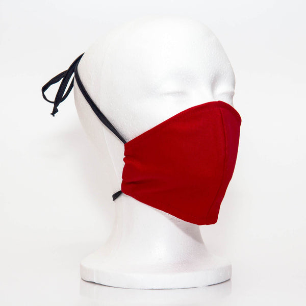 Bright Red Alpha Mask Side View: Solid bright red colour fabric face mask contoured to fit comfortably on your face. This is a 3 layer fabric mask with a middle pocket to insert the filter as the third layer. The bias binding straps is easily adjustable for your comfort and ties behind your head. This mask has a removable filter. This mask an unisex adult fit.