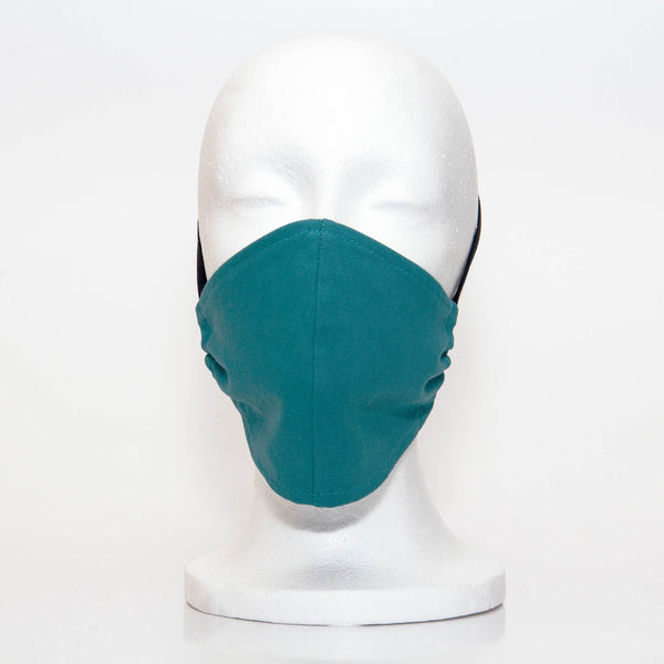 Teal Alpha Mask Front View: Solid teal colour fabric face mask contoured to fit comfortably on your face. This is a 3 layer fabric mask with a middle pocket to insert the filter as the third layer. The bias binding straps is easily adjustable for your comfort and ties behind your head. This mask has a removable filter. This mask an unisex adult fit.