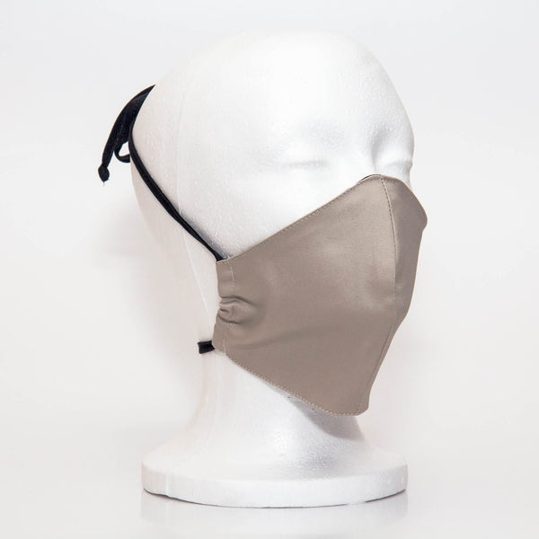 White Sand Alpha Mask Side View: Our white sand colour is a light khaki colour fabric face mask contoured to fit comfortably on your face. This is a 3 layer fabric mask with a middle pocket to insert the filter as the third layer. The bias binding straps is easily adjustable for your comfort and ties behind your head. This mask has a removable filter. This mask an unisex adult fit.