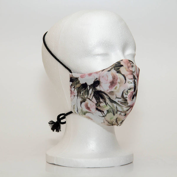 Oltre Print Mask Side View: Pink Peonies print. The soft woven strap is easily adjustable around your head for your comfort. 3 Layer fabric mask with a middle filter layer that is contoured to fit comfortably on your face. Mask will fit women and teen girls.