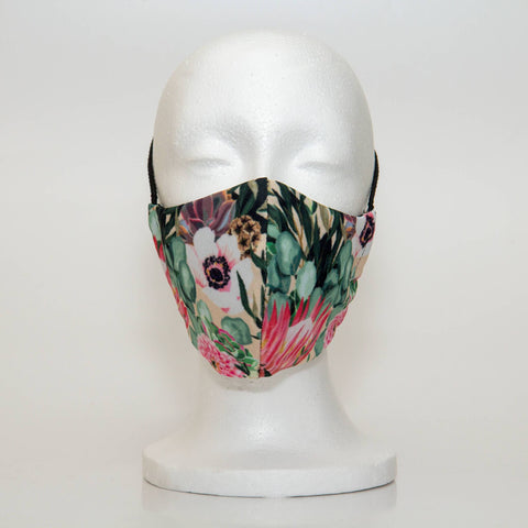 Oltre Print Mask Front View: Fynbos & Flowers print. The uniquely South African fynbos and flowers print truely is a homage to our beautiful country. This beautiful print will elevate your outfit with te muted colours of a bouquet of flowers. 3 Layer fabric mask with a middle filter layer that is contoured to fit comfortably on your face. Mask will fit women and teen girls.