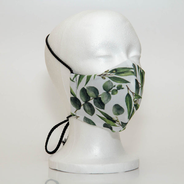 Oltre Print Mask Side View: Green leaves print. The soft woven strap is easily adjustable around your head for your comfort. 3 Layer fabric mask with a middle filter layer that is contoured to fit comfortably on your face. Mask will fit women and teen girls.