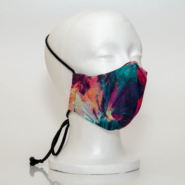 Oltre Print Mask Side View: Teal & Pink Abstract print. The soft woven strap is easily adjustable around your head for your comfort. 3 Layer fabric mask with a middle filter layer that is contoured to fit comfortably on your face. Mask will fit women and teen girls.