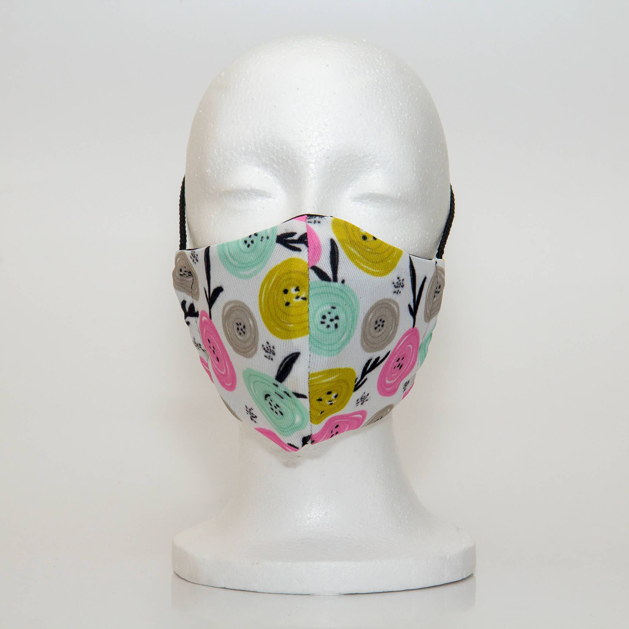 Oltre Print Mask Front View: Multicolour swirls print. The funky multicolour circles make you think of happy apples. The pretty colour combination of yellow, pink, blue and grey is youthful and fun. 3 Layer fabric mask with a middle filter layer that is contoured to fit comfortably on your face. Mask will fit women and teen girls.