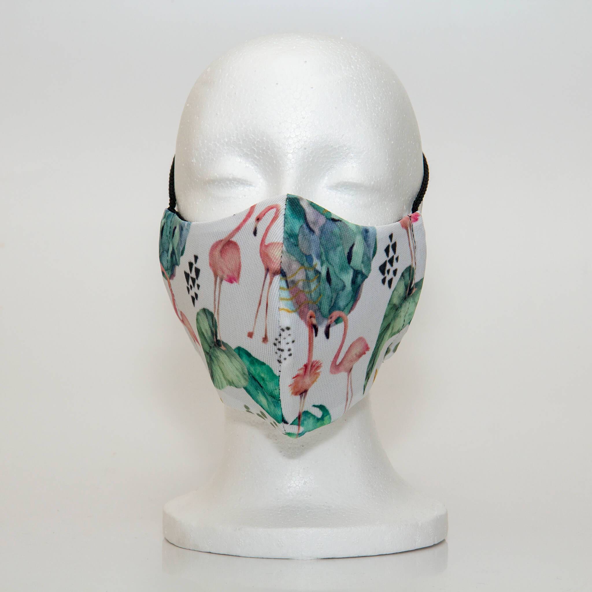 Oltre Print Mask Front View: Flamingos print. The soft, feminine flamingos print is an exquisite print that will elevate your outfit. 3 Layer fabric mask with a middle filter layer that is contoured to fit comfortably on your face. Mask will fit women and teen girls.