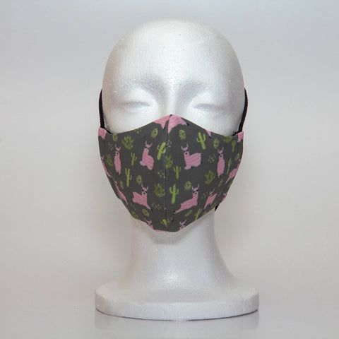 Oltre Print Mask Front View: Pink Llamas print. Our pink Llamas with cacti print is playfl and spunky. 3 Layer fabric mask with a middle filter layer that is contoured to fit comfortably on your face. Mask will fit pre-teen girls between 7 to 12 years old.