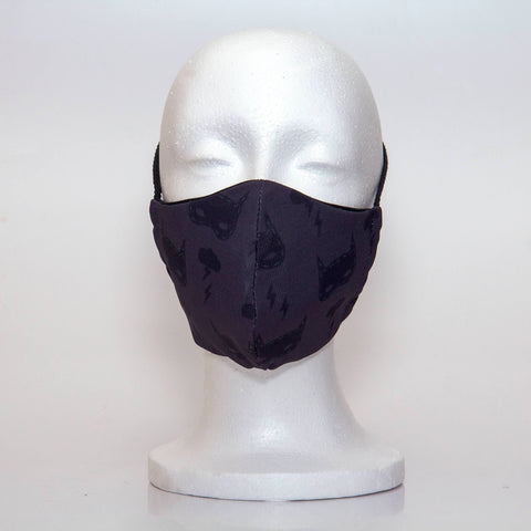 Oltre Print Mask Front View: Batman print. This is a fun and subtle batman print for your inner Batman. 3 Layer fabric mask with a middle filter layer that is contoured to fit comfortably on your face. Mask will fit teen boy from 12 years and older.