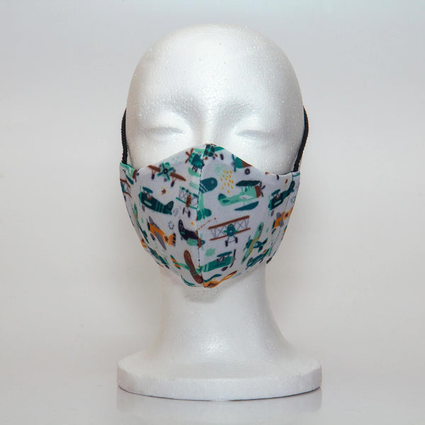 Oltre Print Mask Front View: Planes print. Our plane print is fun and playful while capturing the imagination to fly off to somewhere magical. 3 Layer fabric mask with a middle filter layer that is contoured to fit comfortably on your face. Mask will fit pre school boys between 3 to 6 years old.